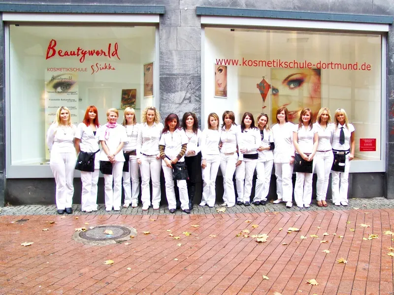 Schulklasse der Kosmetikschule Beautyworld S. Siakka vor dem Schaufenster der Kosmetikschule